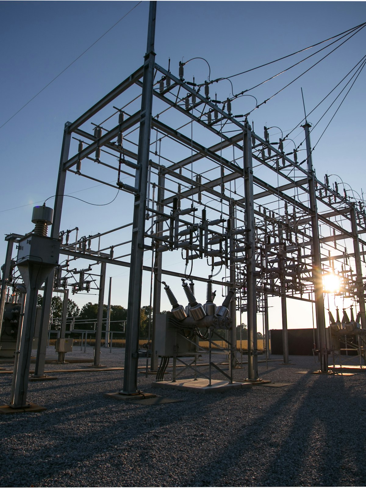 High-voltage substation at dusk with switchgear and busbars.